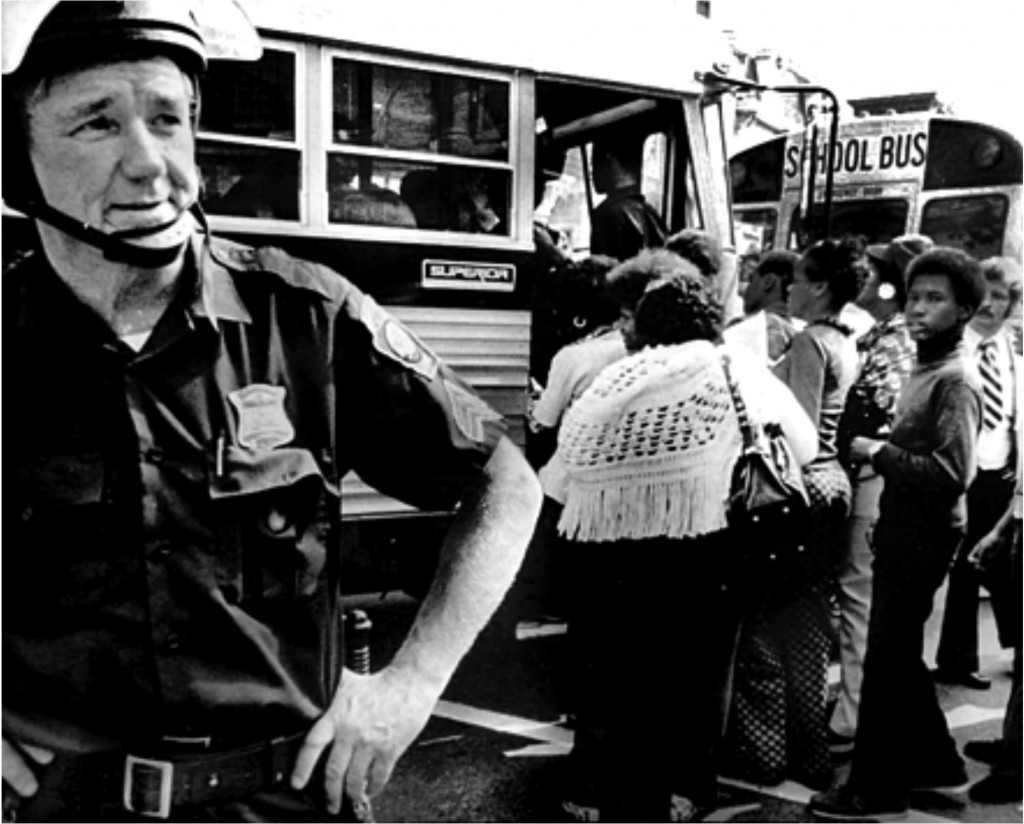 Police  protect school buses in Boston, MA, in 1974 during forced busing to racially integrate schools. Peter Bregg/AP